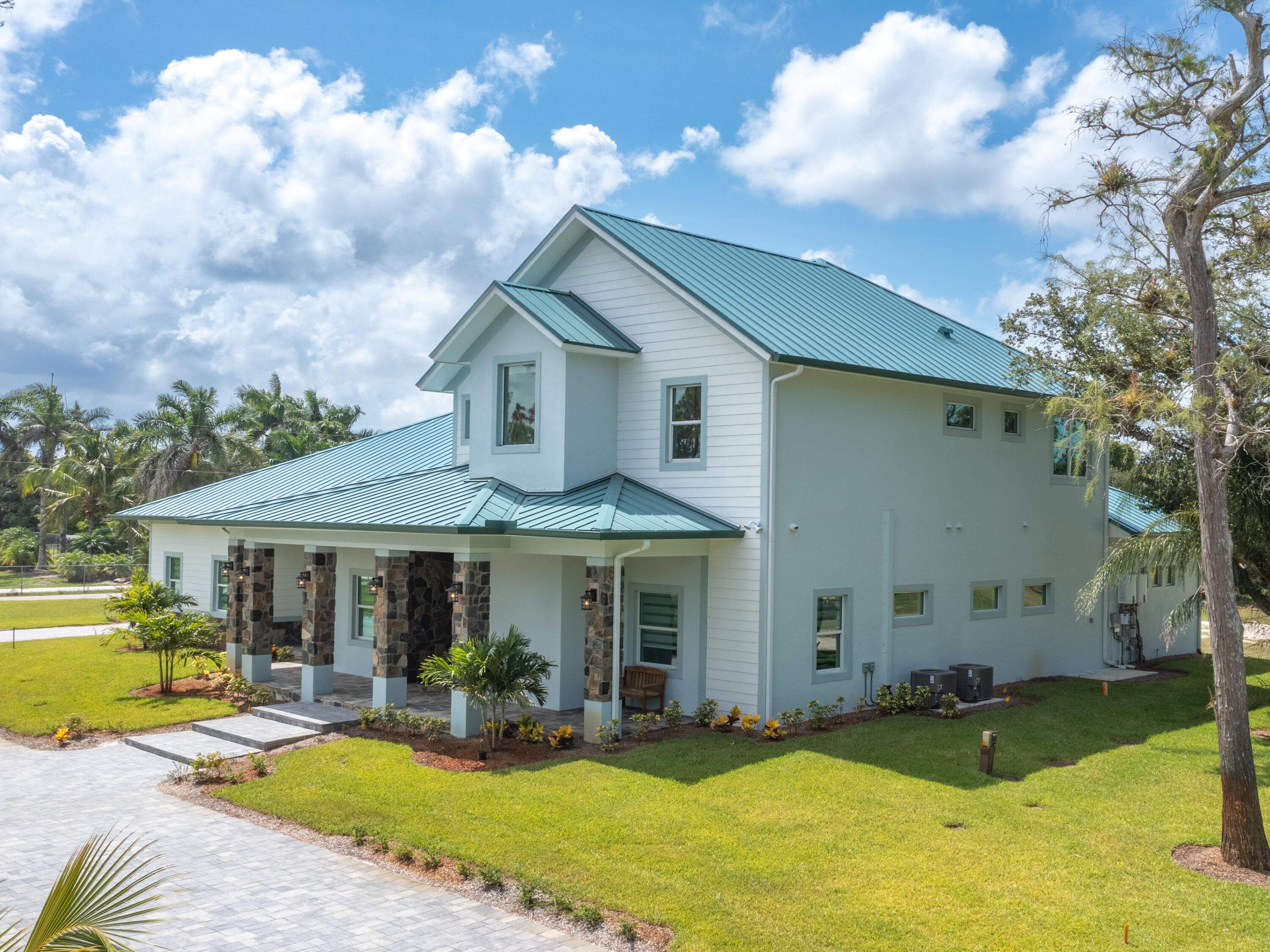 256 Price Street Naples, FL 34113 - Photo 14 of 42 a front view of a house with a yard table and chairs