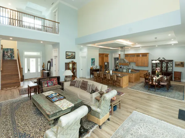 a dining hall with stainless steel appliances kitchen island granite countertop a dining table chairs and view living room