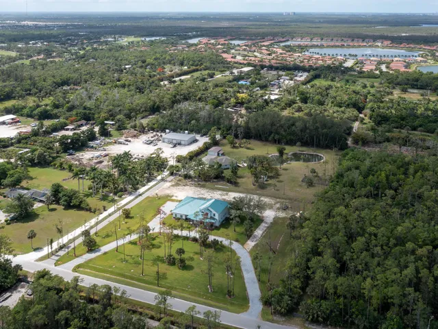 an aerial view of residential houses with outdoor space and trees