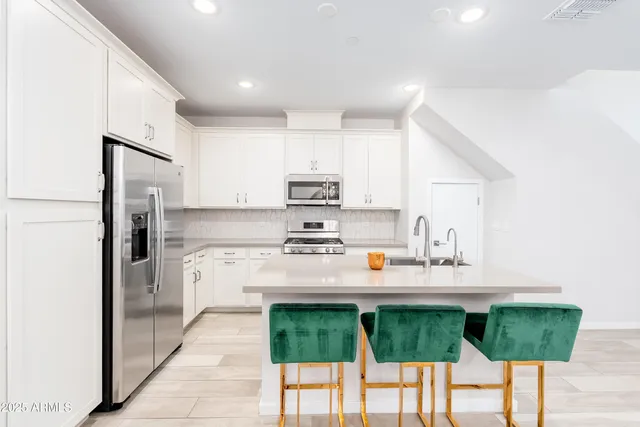 a kitchen with stainless steel appliances granite countertop a stove a sink and a microwave