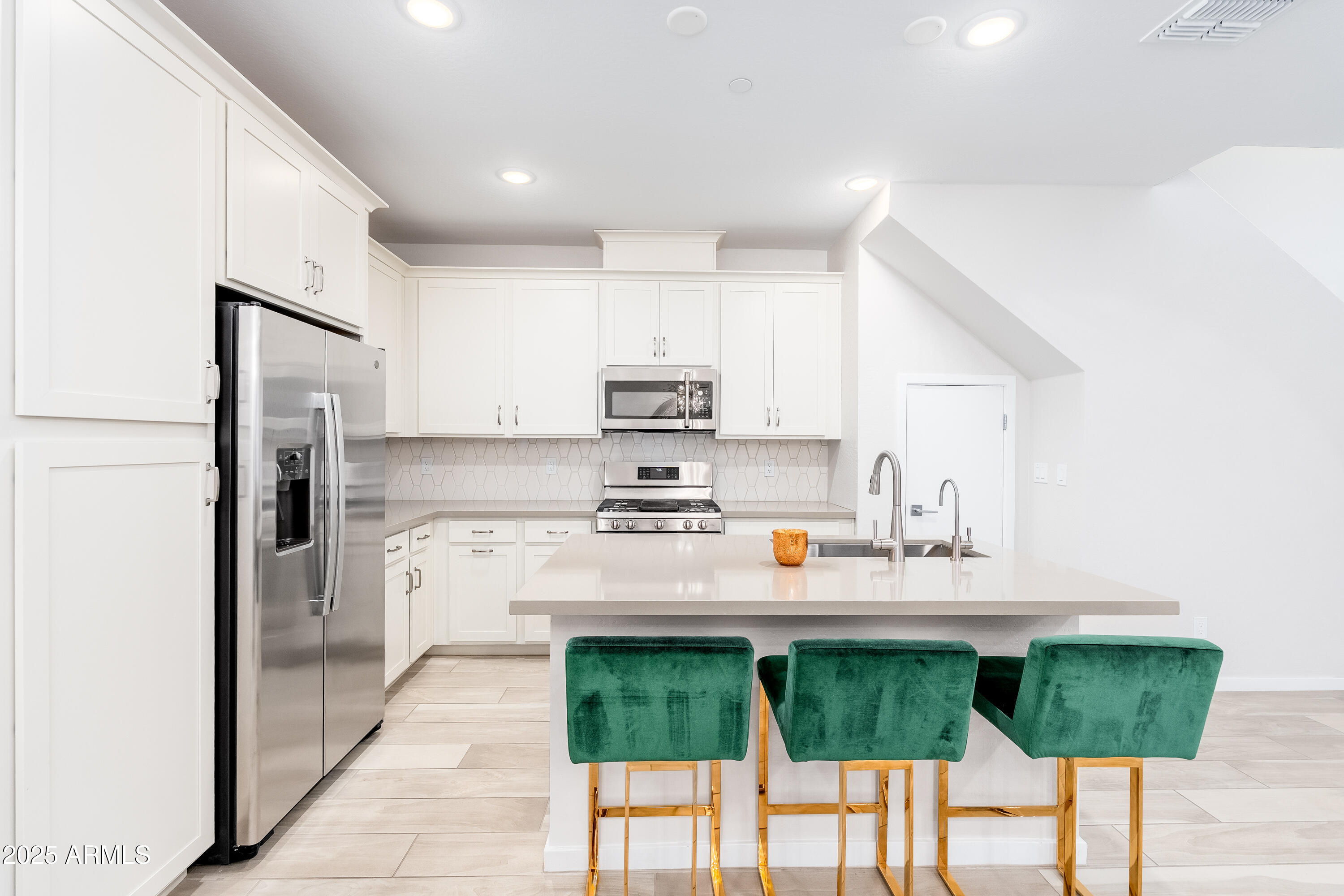 724 East Lark Street, Unit 102 Gilbert, AZ 85297 - Photo 17 of 54 a kitchen with stainless steel appliances kitchen island granite countertop a refrigerator and a stove top oven