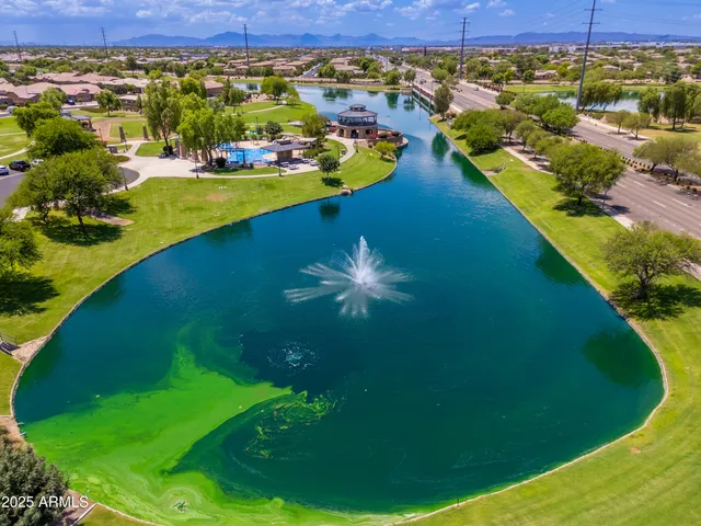 an aerial view of residential houses with outdoor space and lake view