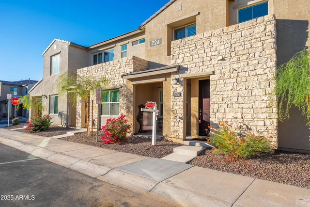 a view of a swimming pool with a lawn chairs under palm trees