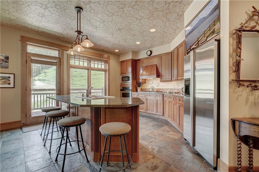 280 Trailhead Drive, Unit 3016 Keystone, CO 80435 - Photo 11 of 35 a kitchen with stainless steel appliances granite countertop a refrigerator a sink a stove and island