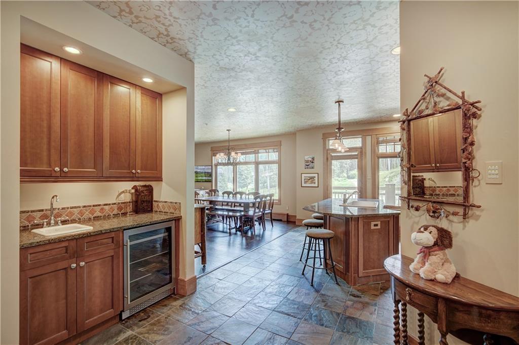 280 Trailhead Drive, Unit 3016 Keystone, CO 80435 - Photo 14 of 35 a kitchen with granite countertop a stove a sink a dining table and chairs