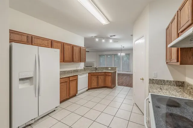 a kitchen with granite countertop a refrigerator and a sink