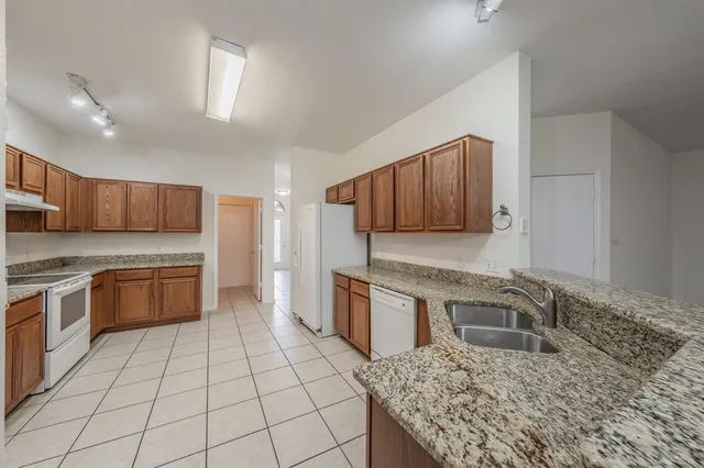 a kitchen with stainless steel appliances granite countertop a stove top oven a sink dishwasher and granite counter tops