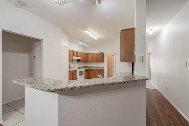 a kitchen with granite countertop a sink and a refrigerator