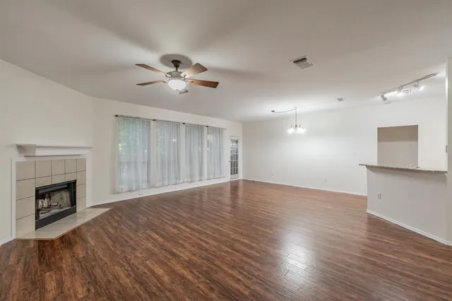 a view of empty room with wooden floor and fireplace