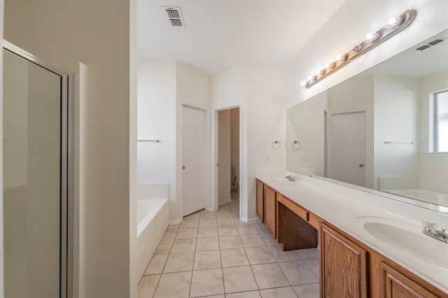 a spacious bathroom with a bathtub sink and mirror