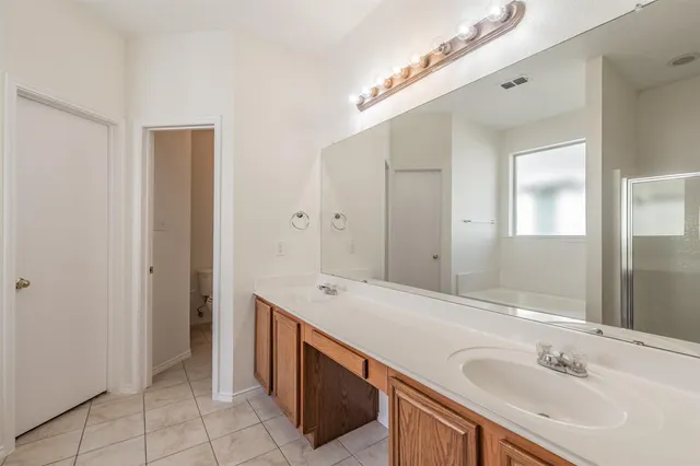 a spacious bathroom with a shower sink and mirror