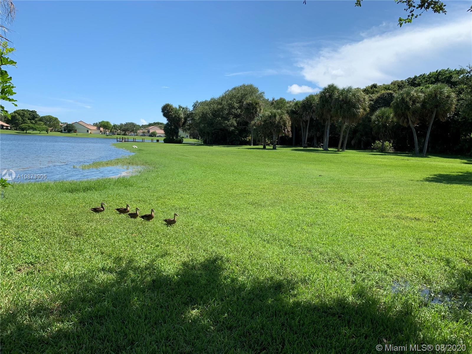492 Hardwood Place, Unit 492 Boca Raton, FL 33431 - Photo 18 of 21 a view of a garden with a building in the background