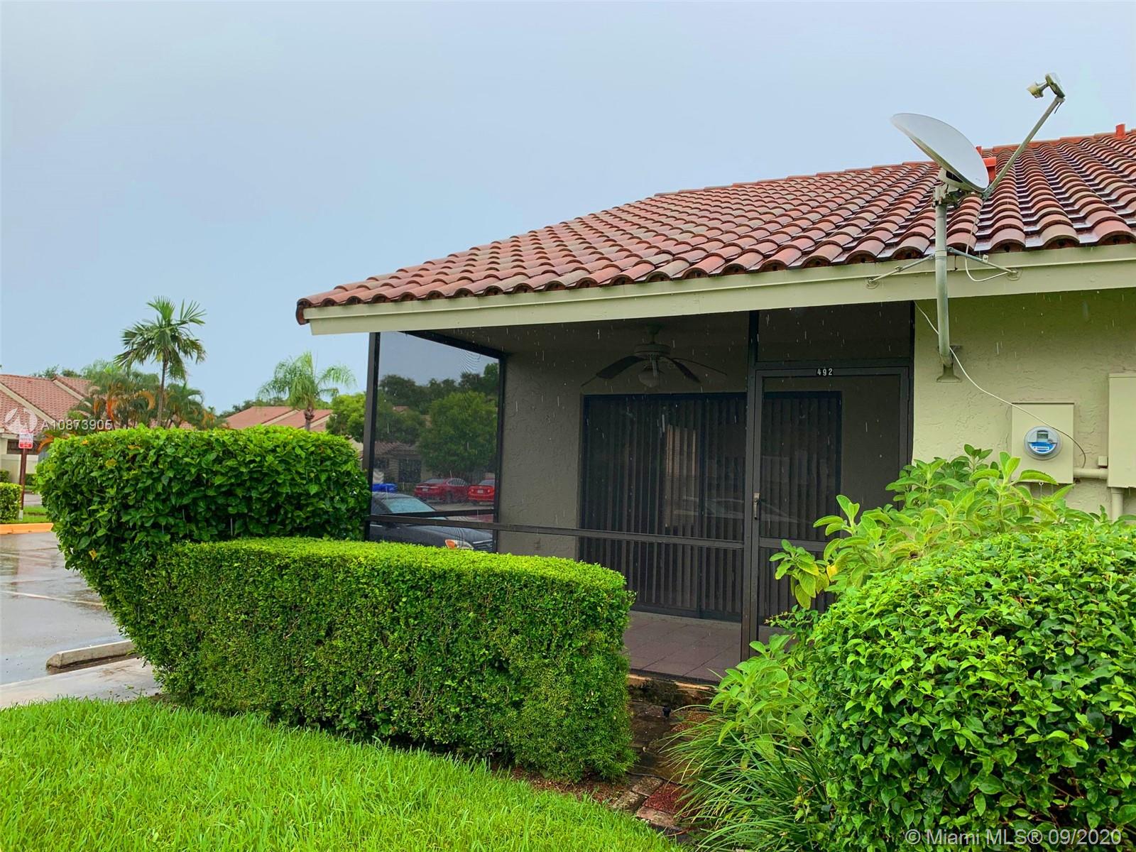 492 Hardwood Place, Unit 492 Boca Raton, FL 33431 - Photo 5 of 21 a view of a house with brick walls and a yard with plants