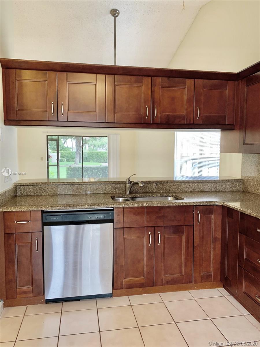 492 Hardwood Place, Unit 492 Boca Raton, FL 33431 - Photo 8 of 21 a kitchen with stainless steel appliances granite countertop a stove a sink and a microwave