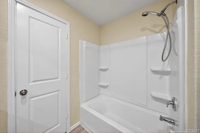 a bathroom with a bath tub with a shower