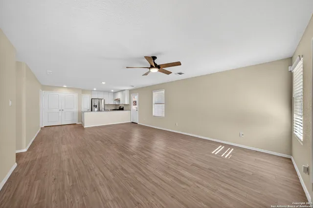 a view of a livingroom with wooden floor and a ceiling fan