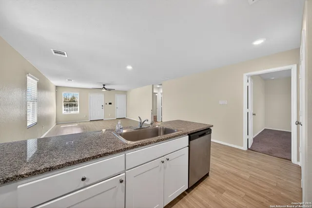 a kitchen with granite countertop a sink and a wooden floor