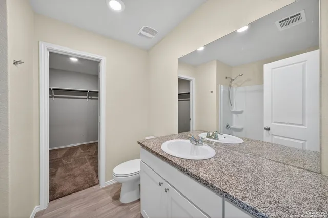 a bathroom with a granite countertop sink toilet and shower