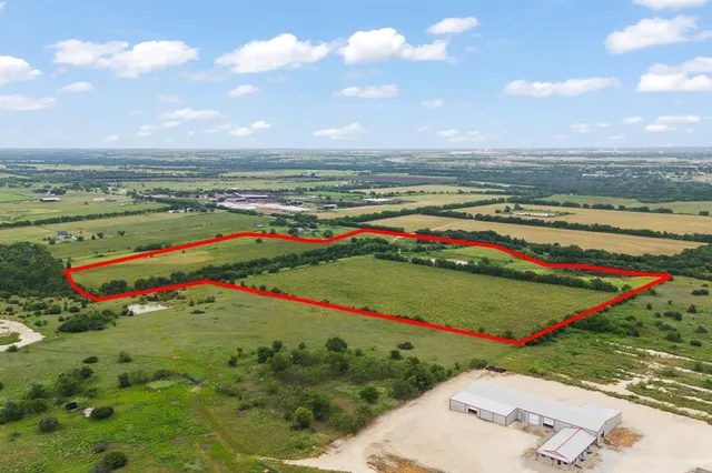 a view of a road with a big yard and potted plants