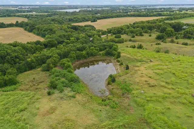 a view of a lake with green field and mountains