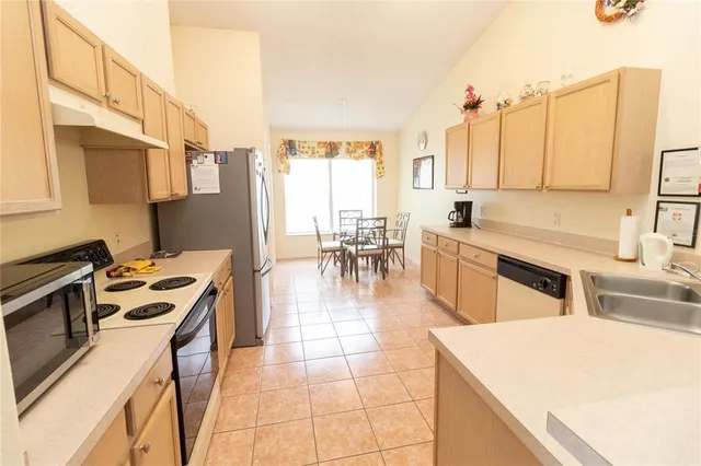 a kitchen with a stove a sink a counter top space and cabinets