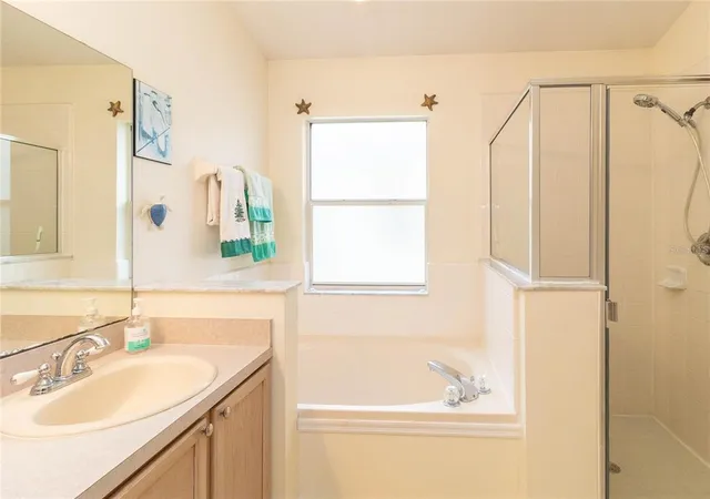 a bathroom with a tub sink and mirror