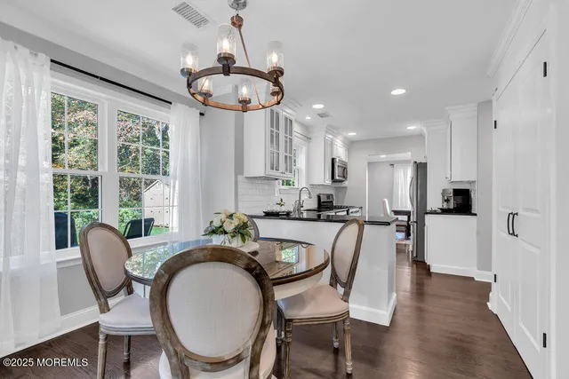 a dining room with furniture a chandelier and wooden floor