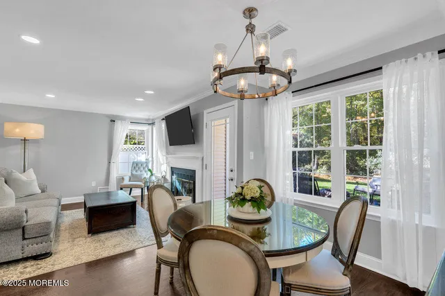 a dining room with furniture a chandelier and wooden floor
