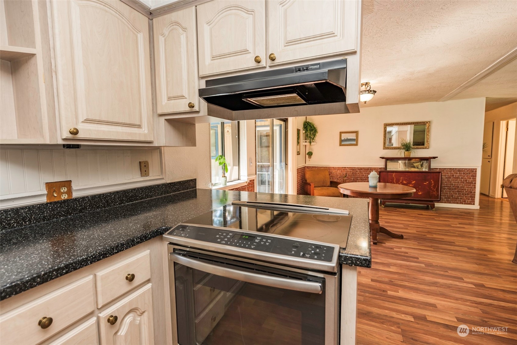 306 Webb Road Sequim, WA 98382 - Photo 14 of 40 a kitchen with granite countertop a stove and white cabinets