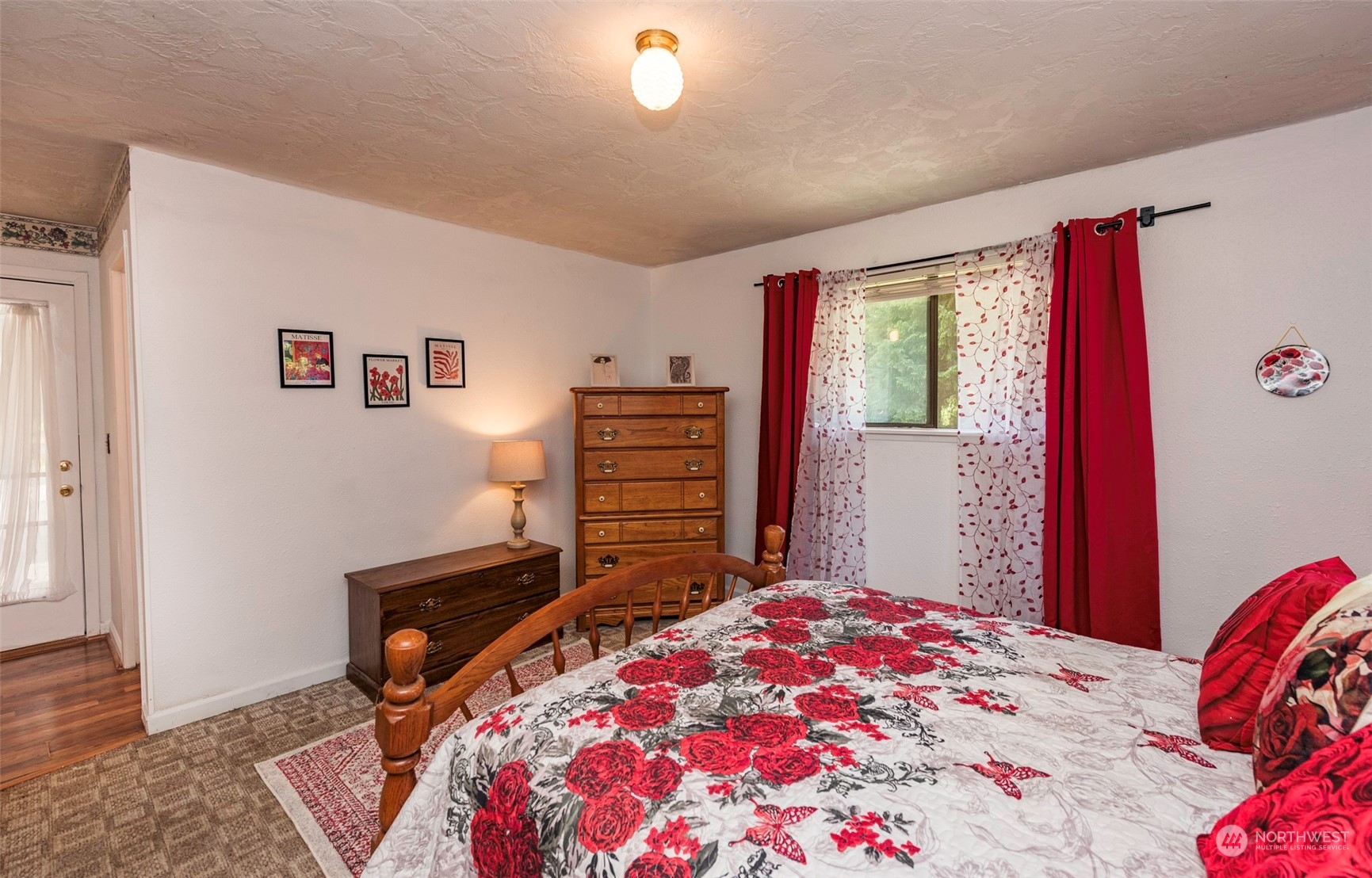 306 Webb Road Sequim, WA 98382 - Photo 23 of 40 a bedroom with a bed and a dresser with wooden floor