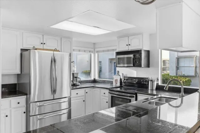 a kitchen with stainless steel appliances granite countertop a refrigerator stove and microwave