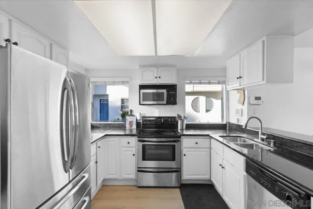 a kitchen with stainless steel appliances a refrigerator stove and sink