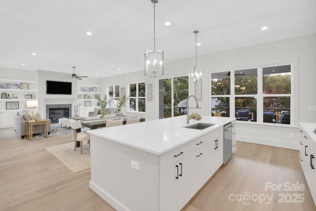 a large white kitchen with a large window and chairs