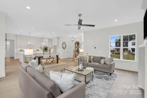 a living room with furniture and view of kitchen