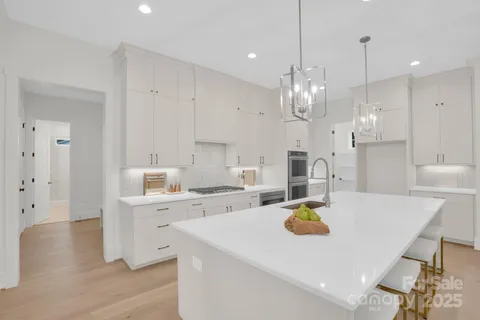 a kitchen with a sink a stove and chairs