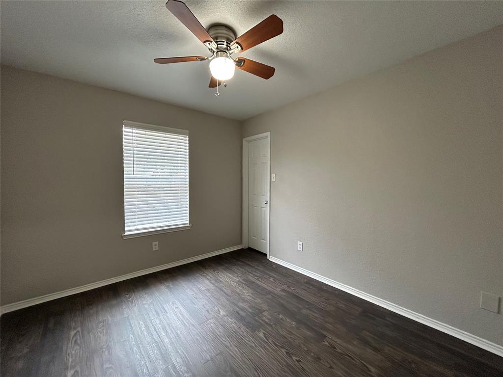 1249 Round Pen Run Fort Worth, TX 76052 - Photo 22 of 28 an empty room with wooden floor and windows