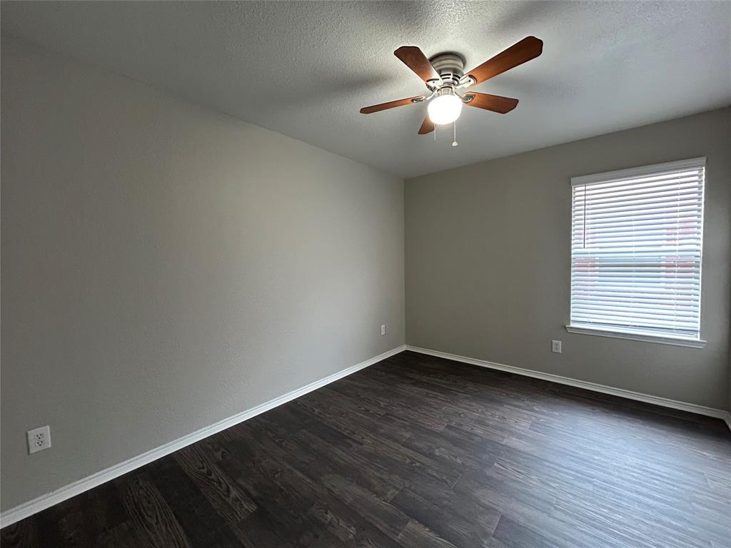 1249 Round Pen Run Fort Worth, TX 76052 - Photo 24 of 28 an empty room with wooden floor and ceiling fan