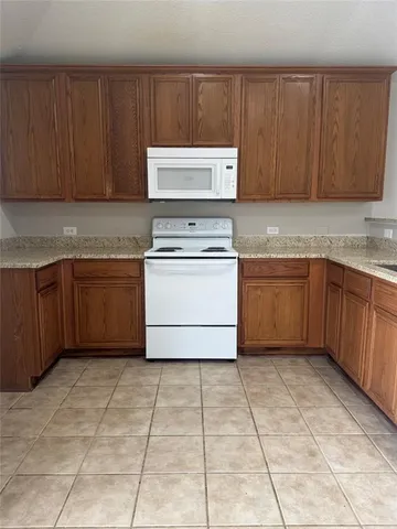 a kitchen with a cabinets and white appliances