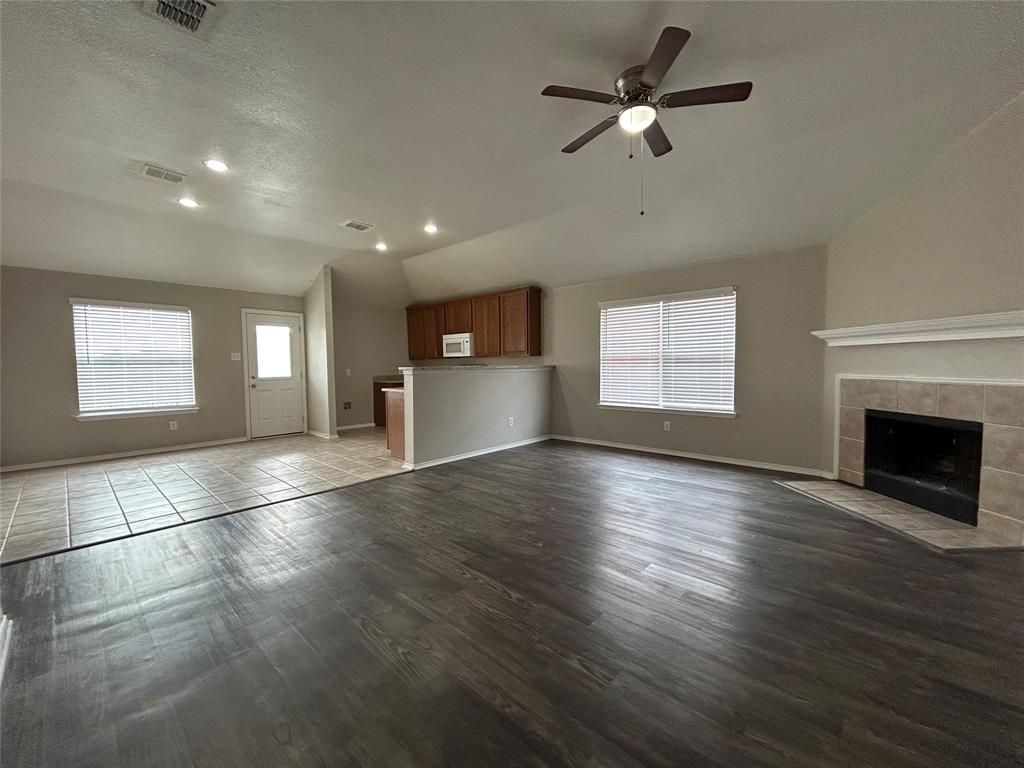 1249 Round Pen Run Fort Worth, TX 76052 - Photo 6 of 28 an empty room with wooden floor fireplace and windows