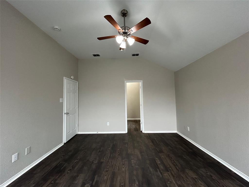 1249 Round Pen Run Fort Worth, TX 76052 - Photo 9 of 28 an empty room with wooden floor and ceiling fan