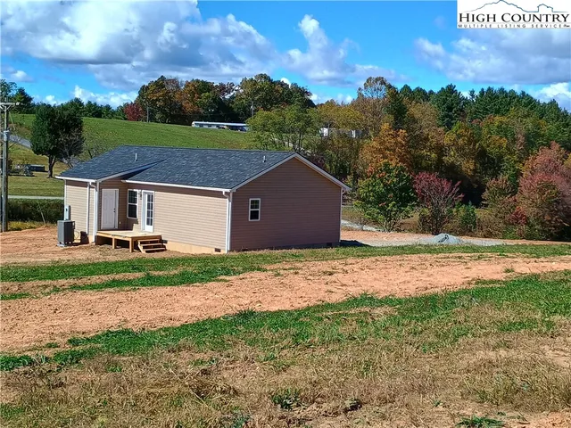 a aerial view of a house next to a yard and large tree