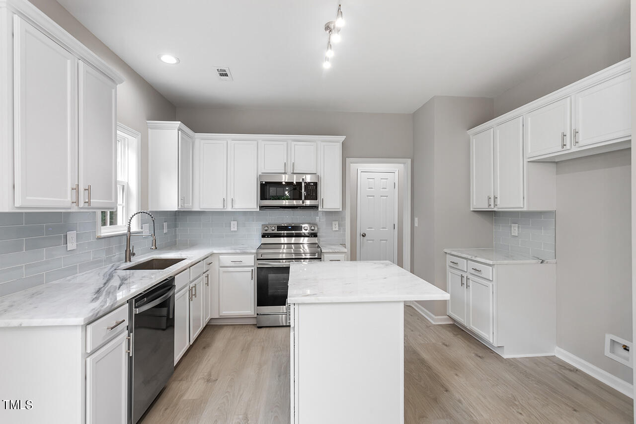 617 McCarthy Drive Clayton, NC 27527 - Photo 2 of 44 a kitchen with appliances a sink and cabinets
