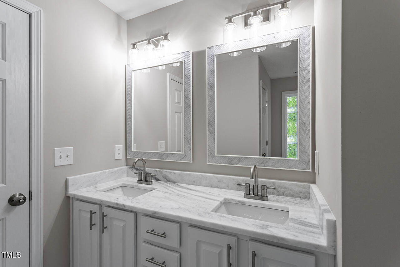 617 McCarthy Drive Clayton, NC 27527 - Photo 22 of 44 a bathroom with a granite countertop sink and a mirror