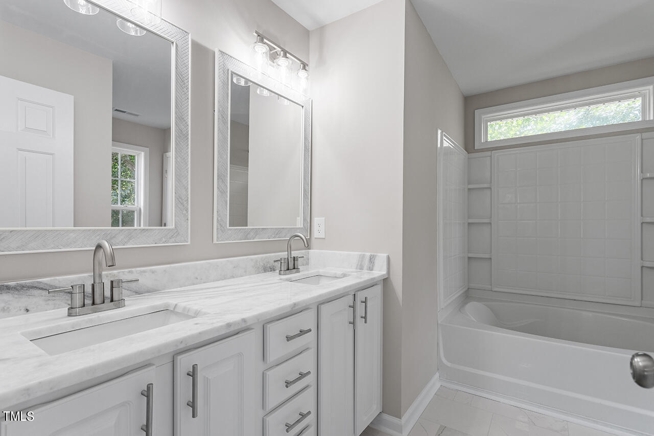 617 McCarthy Drive Clayton, NC 27527 - Photo 8 of 44 a bathroom with a sink double vanity granite tub shower and a mirror