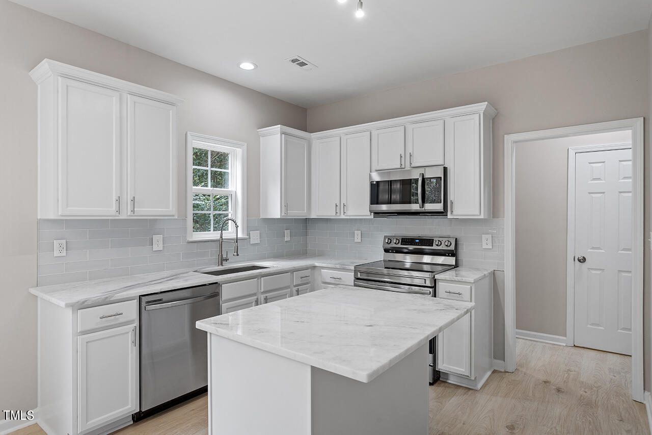 617 McCarthy Drive Clayton, NC 27527 - Photo 9 of 44 a kitchen with sink a microwave and cabinets