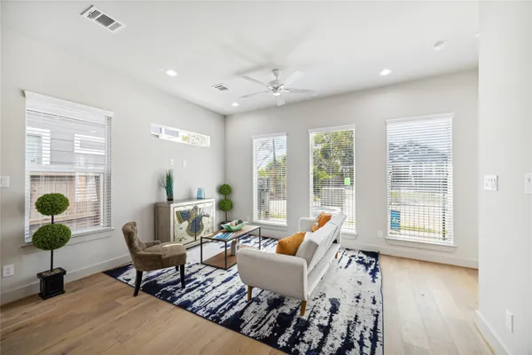 a kitchen with stainless steel appliances kitchen island granite countertop a stove a refrigerator a oven a sink with island white cabinets and wooden floor