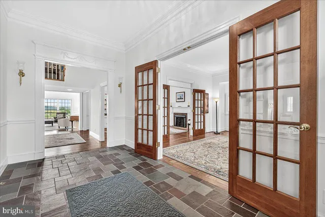 a view of a dining room and livingroom with furniture wooden floor a rug and a chandelier