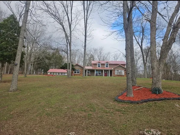 an aerial view of a house with a yard and large trees