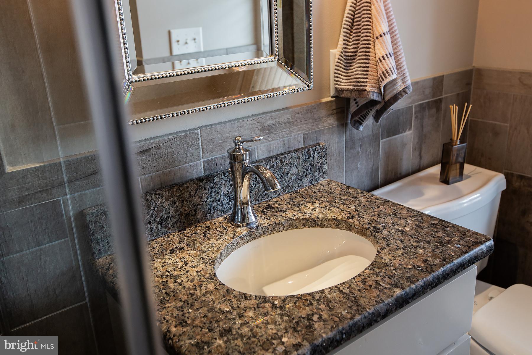 125 South Duke Street Lancaster, PA 17602 - Photo 18 of 40 a bathroom with a granite countertop sink and a mirror