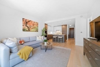 1 Franklin Street, Unit 2406 Boston, MA 02110 - Photo 3 of 22 a living room with furniture and a flat screen tv